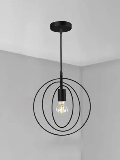 Black metal pendant light with concentric circular rings and filament bulb in decorbites industrial chandelier design