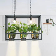 Black metal frame hanging light fixture with three glass plant pots holding green leafy plants by DecorBites™