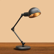 Black metal DecorBites™ industrial metal swing arm table lamp with gold-lined dome shade and 3-joint swing arm