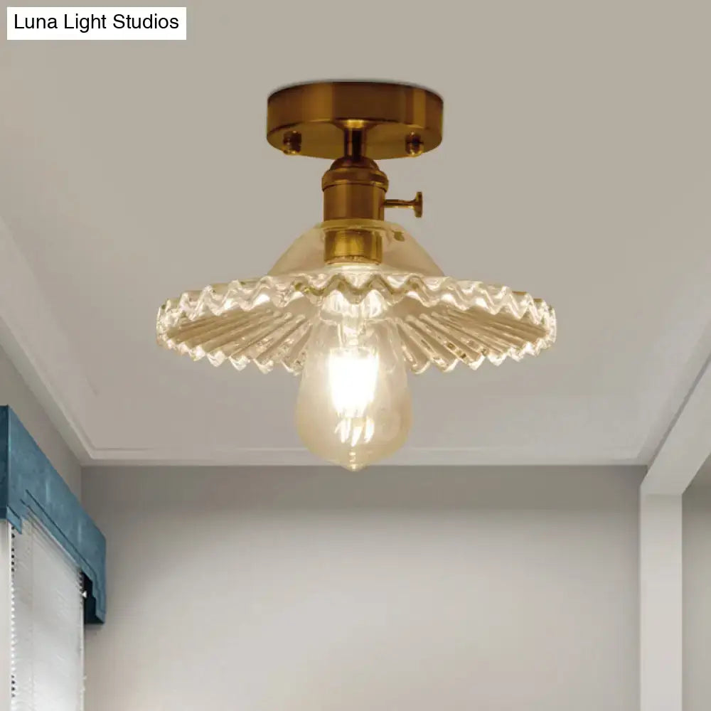 Brass-finished one-light ceiling light with clear scalloped ribbed glass shade and exposed bulb by DecorBites™