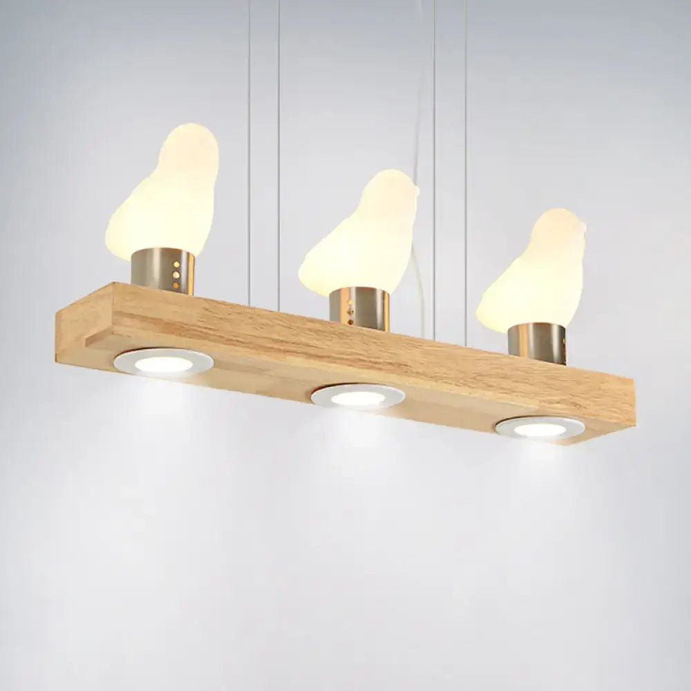 Decorbites ivory glass bird island pendant lighting fixture with three warm glowing bird island pendant lamps on wood plank
