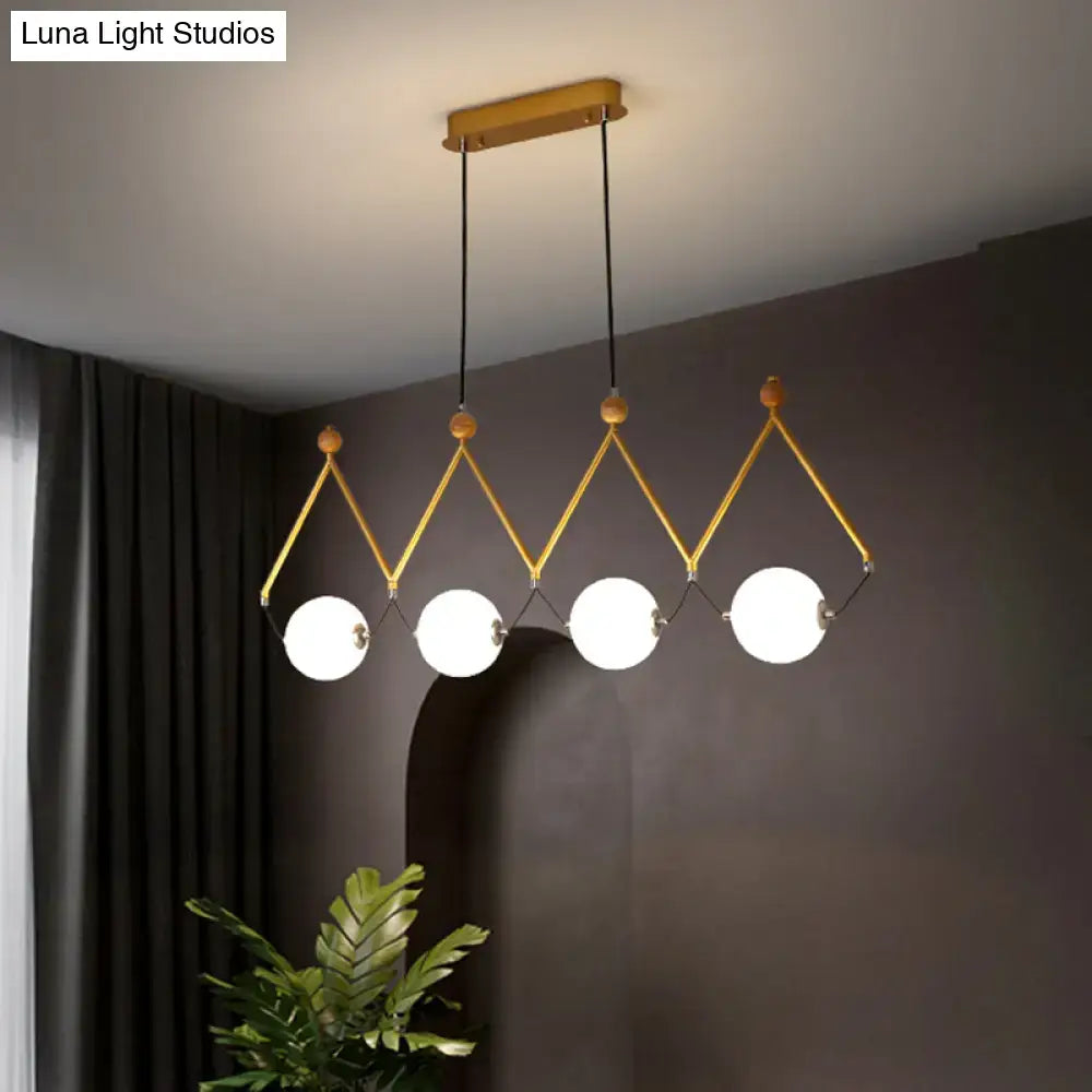 Modern gold-toned DecorBites™ suspension light with four ivory glass balls, wooden accents, and black cords ideal for restaurants