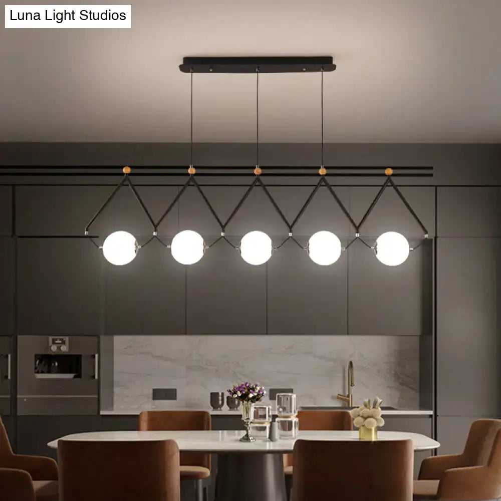 Modern black metal suspension light with five white glass balls in a geometric diamond pattern by DecorBites™