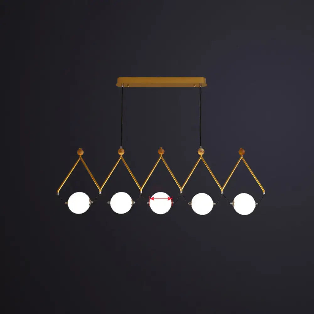 Gold-toned geometric pendant suspension light with five ivory glass balls on black cords from wooden ceiling mount