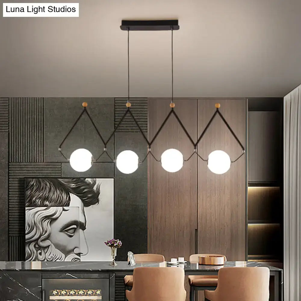 Modern black metal suspension light with four ivory glass spheres in geometric triangular frames for restaurant use