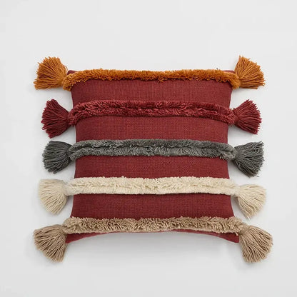 A rectangular rust-red decorbites knit boho cushion cover with earthy fringe bands and tassels for living room decor
