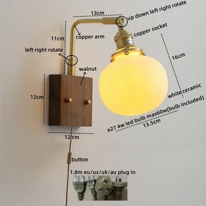 A warm glowing white ceramic globe wall sconce with brass copper arm and walnut plate decorbites led ceramic light fixture