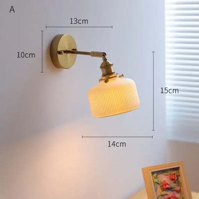 Brass-finished decorbites led ceramic wall sconce with ribbed warm-toned glass shade and knob switch for mirror lighting