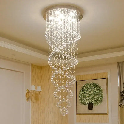 A cascading decorbites led chandelier with clear faceted beads and a circular metallic base for luxury home decor