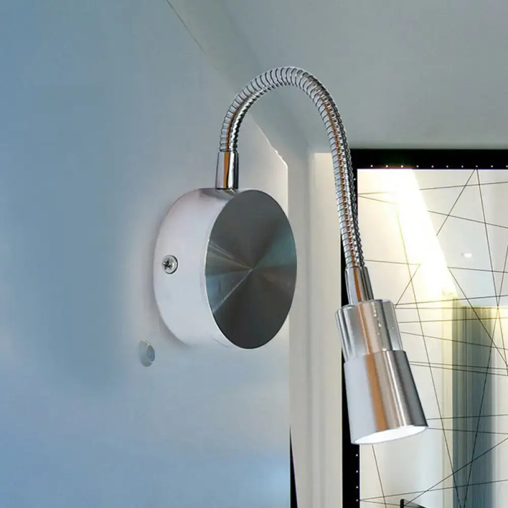 A sleek chrome flexible gooseneck reading light with a white base and mini metal shade for bedroom use