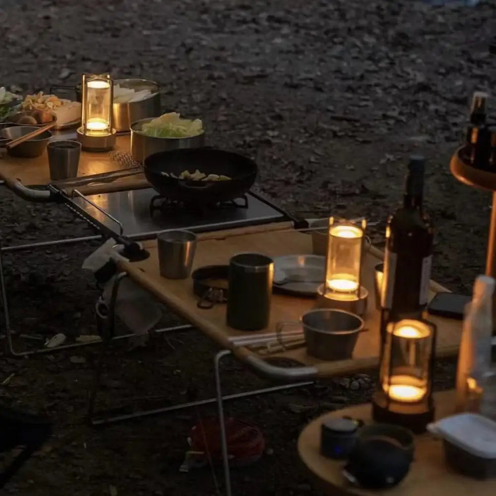 A sleek modern camping table with a light wood top and metal frame for use with decorbites™ led crystal table lamp