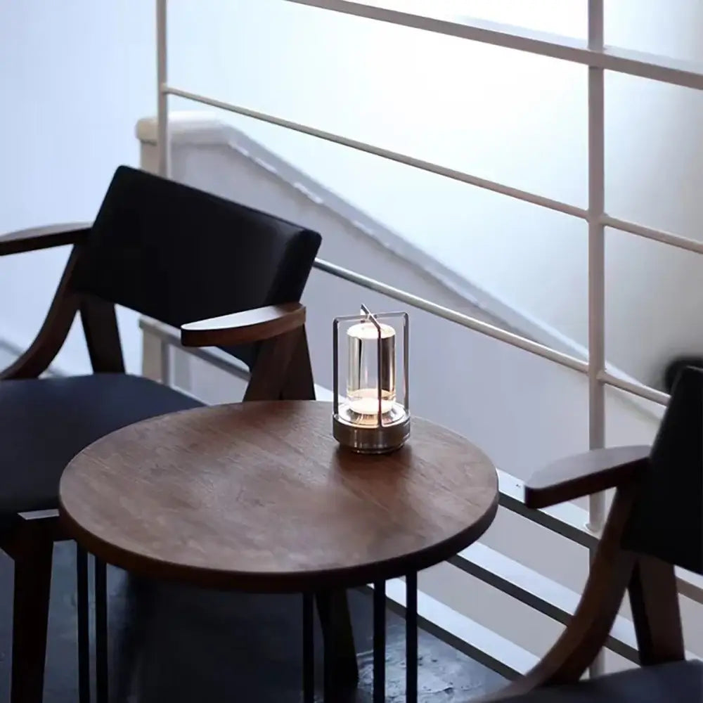 A sleek DecorBites™ LED crystal table lamp with metallic frame and clear glass panels on a wooden table