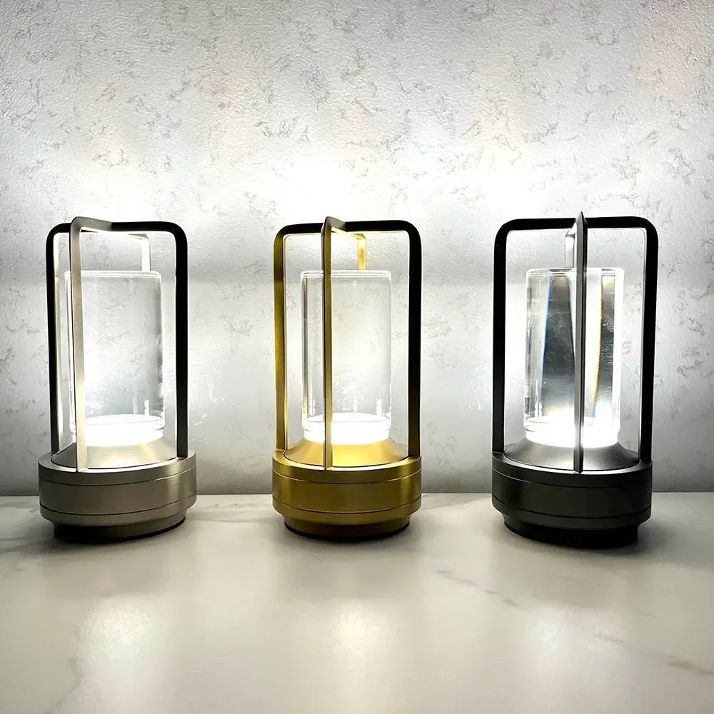 Three modern led crystal table lamps with sleek metal frames and clear glass enclosures for decorative lighting