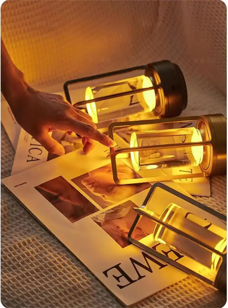 Three glowing decorbites™ led crystal table lamps with clear glass and black metal frames on a textured surface