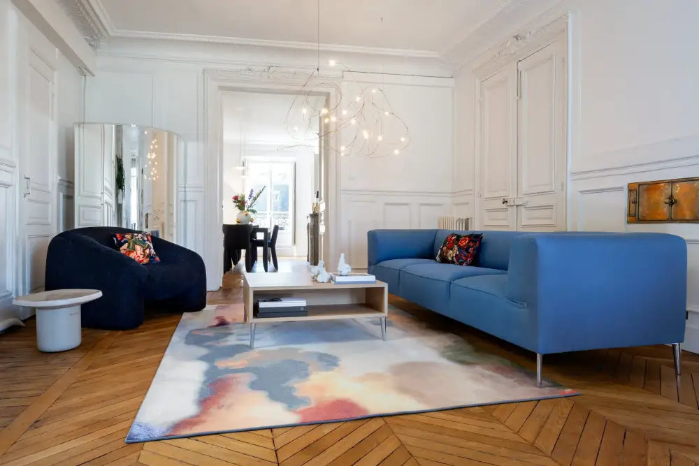 Blue upholstered sofa with sleek metal legs and decorative pillows paired with engineering minimal led firefly chandelier