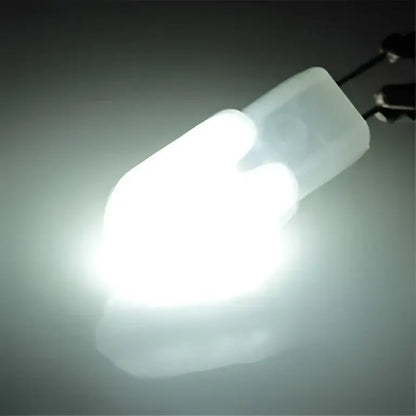 A bright white decorbites led g4 bulb with translucent frosted housing and metallic bi-pin contacts at the base