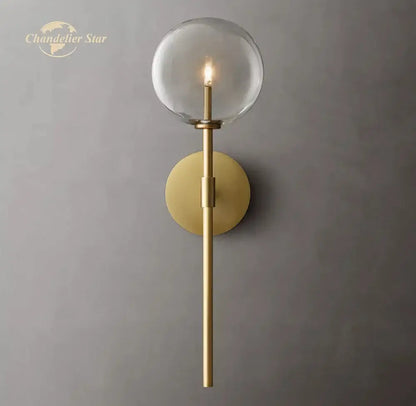Gold-toned decorbites led glass globe wall sconce with clear glass globe and slender stem for modern indoor lighting