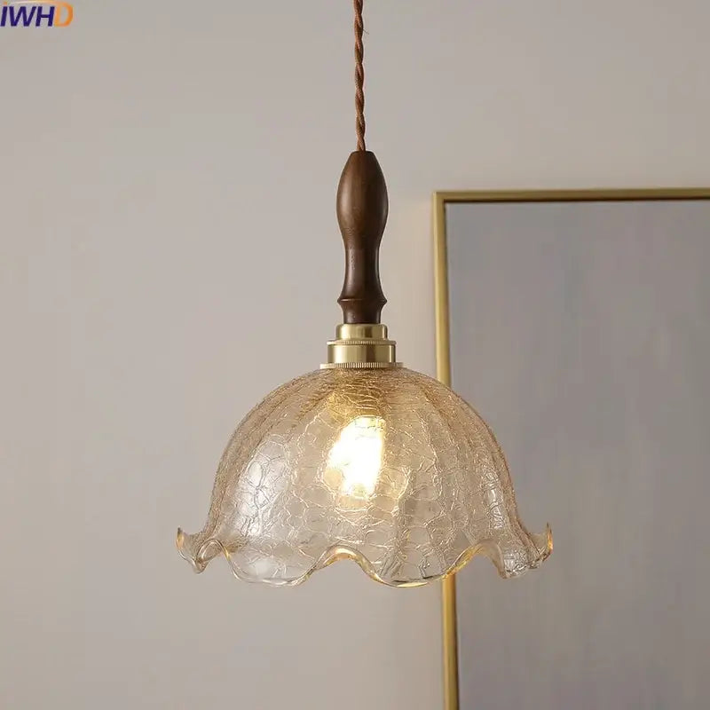 A warm-toned textured glass pendant light with dark wood handle and brass accents decorbites led glass chandelier