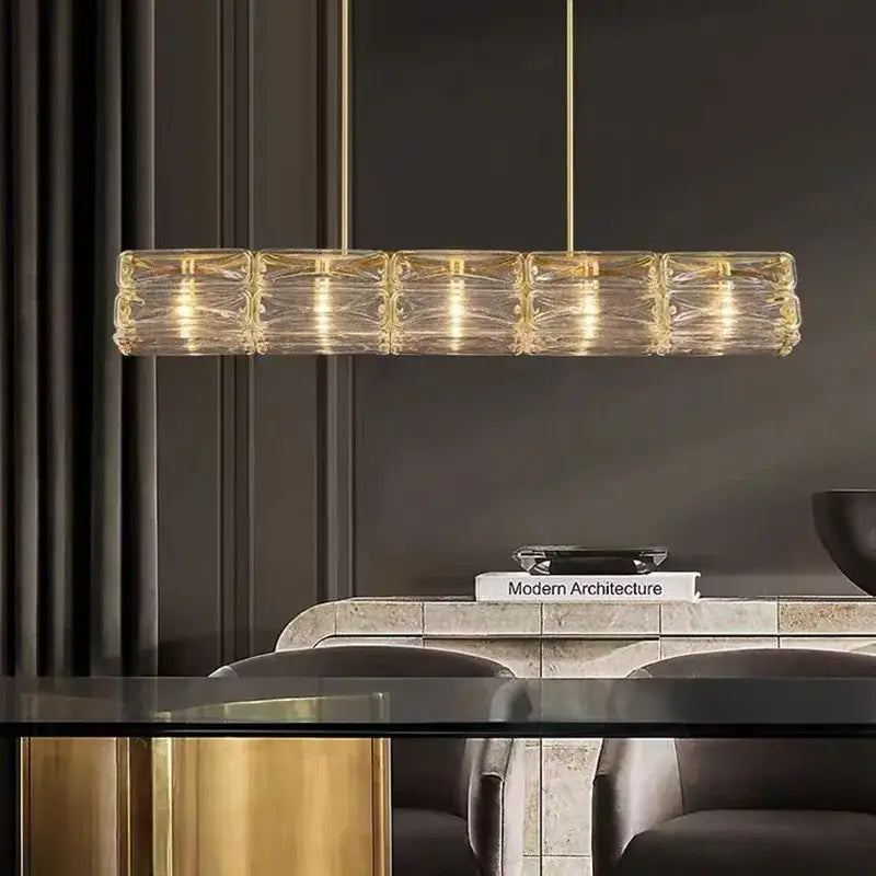 A modern decorbites led glass pendant light with gold metal frame and clear textured glass for warm illumination