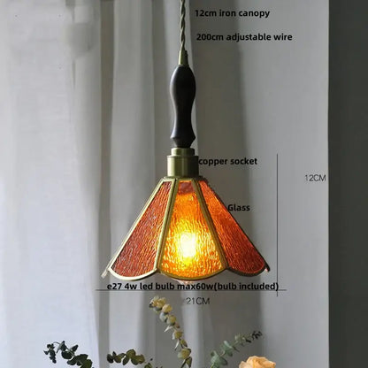 A warm amber-colored decorbites led glass pendant light with brass frame and dark wooden handle for modern decor