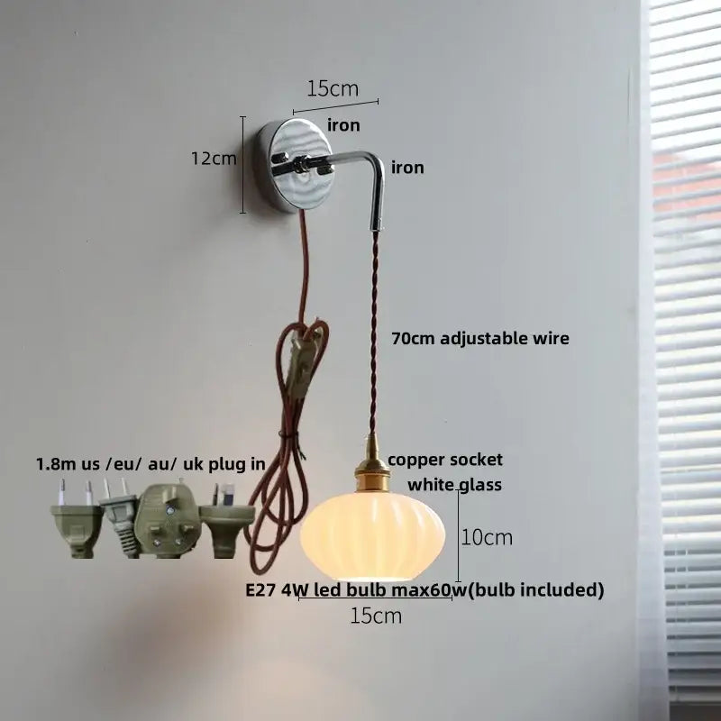 A warm glowing decorbites led glass wall light with ribbed white glass shade and brass fittings for bedroom use
