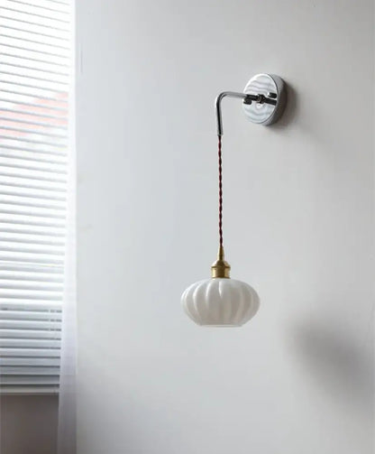 DecorBites™ led glass wall light features a white ribbed glass pendant with brass fixture and braided brown cord