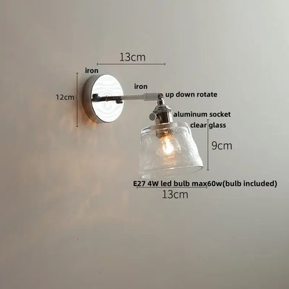 A sleek, adjustable wall light with polished iron base and clear textured glass shade by DecorBites LED Glass