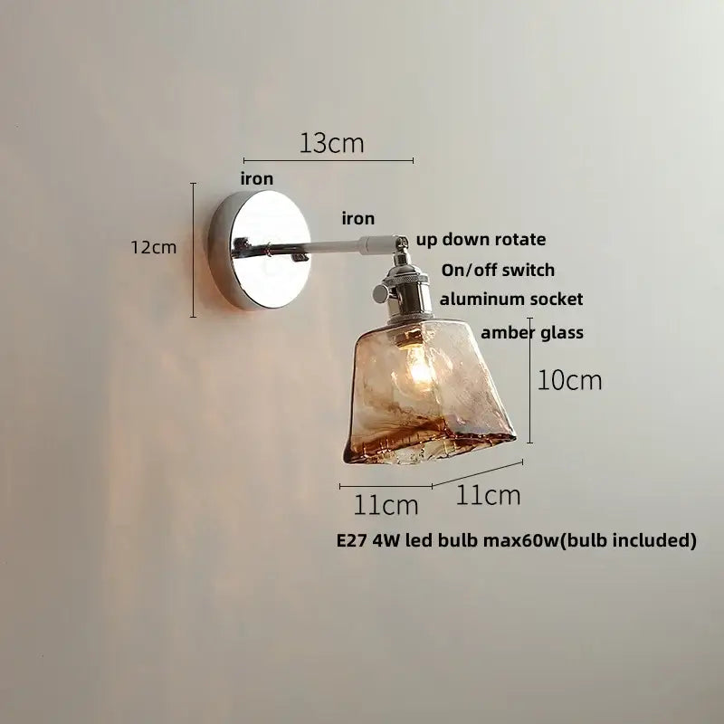 A sleek decorbites led glass wall light with polished iron base amber glass shade and adjustable arm for bedside use