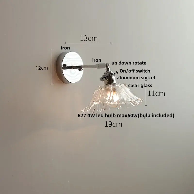 A sleek decorbites led glass wall light with polished iron arm and clear petal-shaped shade for modern bedside use