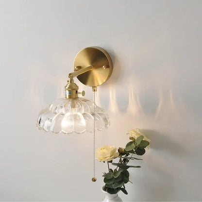 Brass-finished decorbites led glass wall sconce with clear scalloped glass shade and attached pull-chain switch