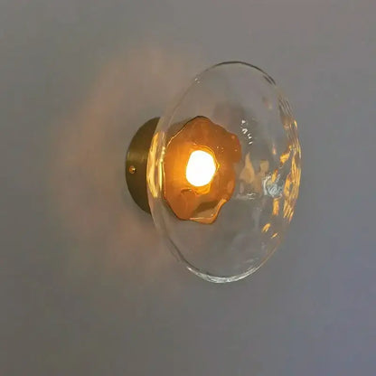 Clear textured glass globe wall sconce with warm amber LED light and brass plate by DecorBites LED glass for living room