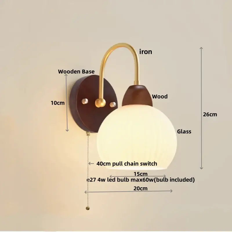 DecorBites led glass wall sconce with warm-toned glass globe brass arm dark wood base and pull chain switch