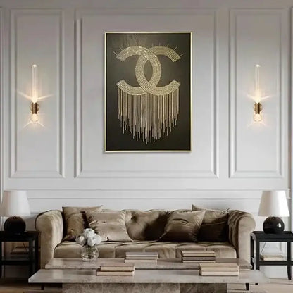 Gold chanel logo artwork with sparkling embellishments and dangling chains on decorbites™ gold glass wall sconces