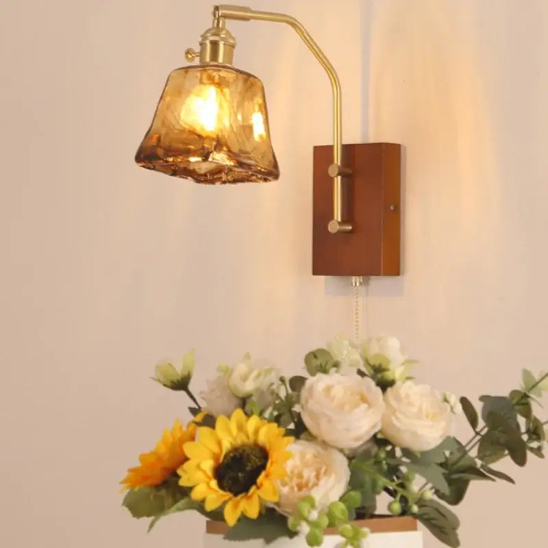 DecorBites™ brass-finished LED wall sconce with textured amber glass shade and wooden backplate for living spaces