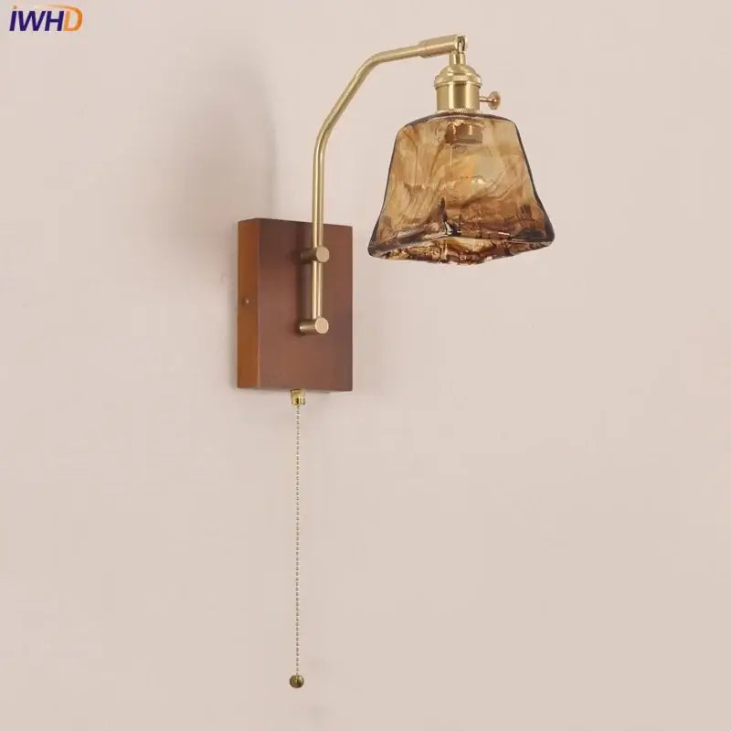 DecorBites™ brass-finished wall lamp with textured amber glass shade and wooden base for living room and bedroom use