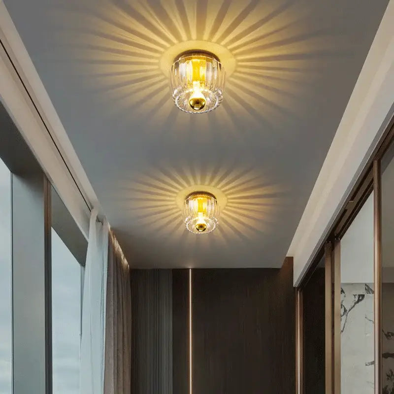 Two elegant gold-finished decorbites led indoor glass wall sconces with clear shades emitting warm glow for living room