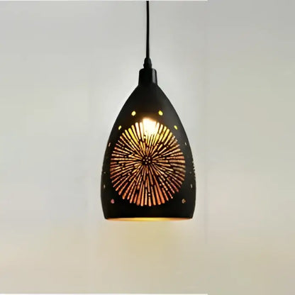 Black decorbites led iron cage pendant light with geometric sunburst cutout design emitting warm golden light