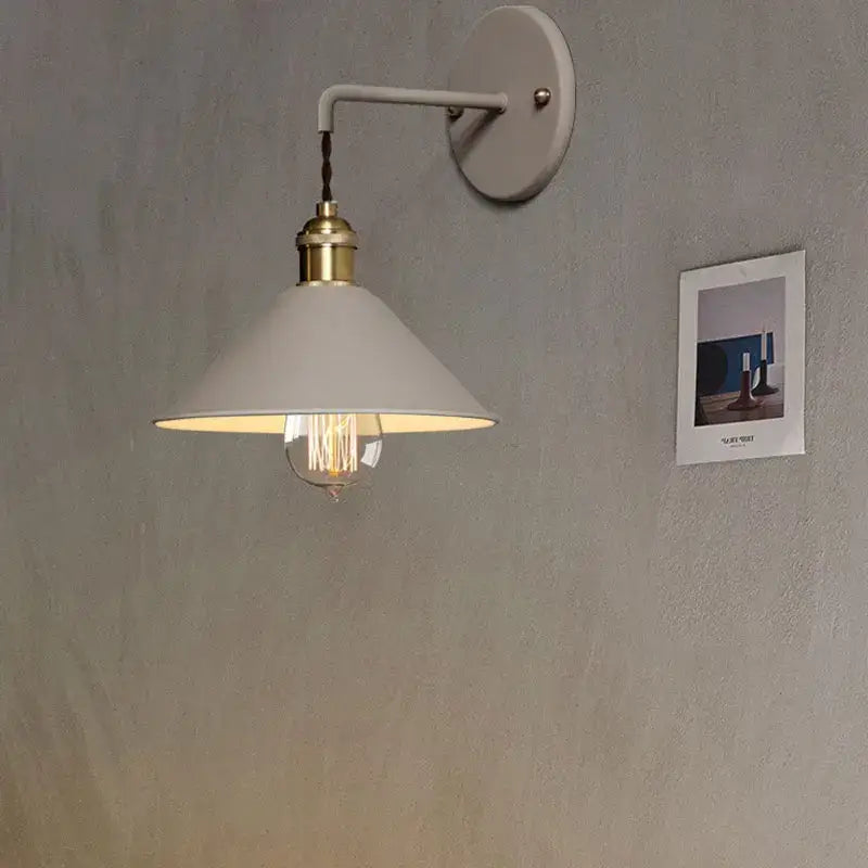 A white conical shade wall light with brass-finished base and exposed filament bulb from decorbites led macarons colorful collection