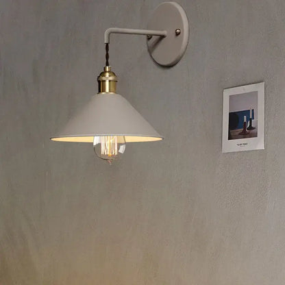A white conical shade wall light with brass-finished base and exposed filament bulb from decorbites led macarons colorful collection
