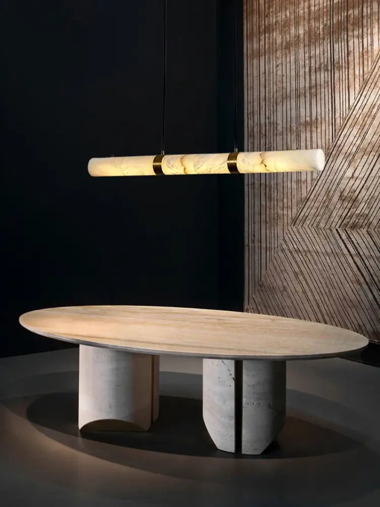 Modern oval dining table with light marble top and minimalist concrete legs illuminated by decorBites led marble white alabaster hanging lamps