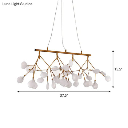 Gold-toned metal tree branch ceiling light with frosted glass globes for minimalist dining room decor by DecorBites™