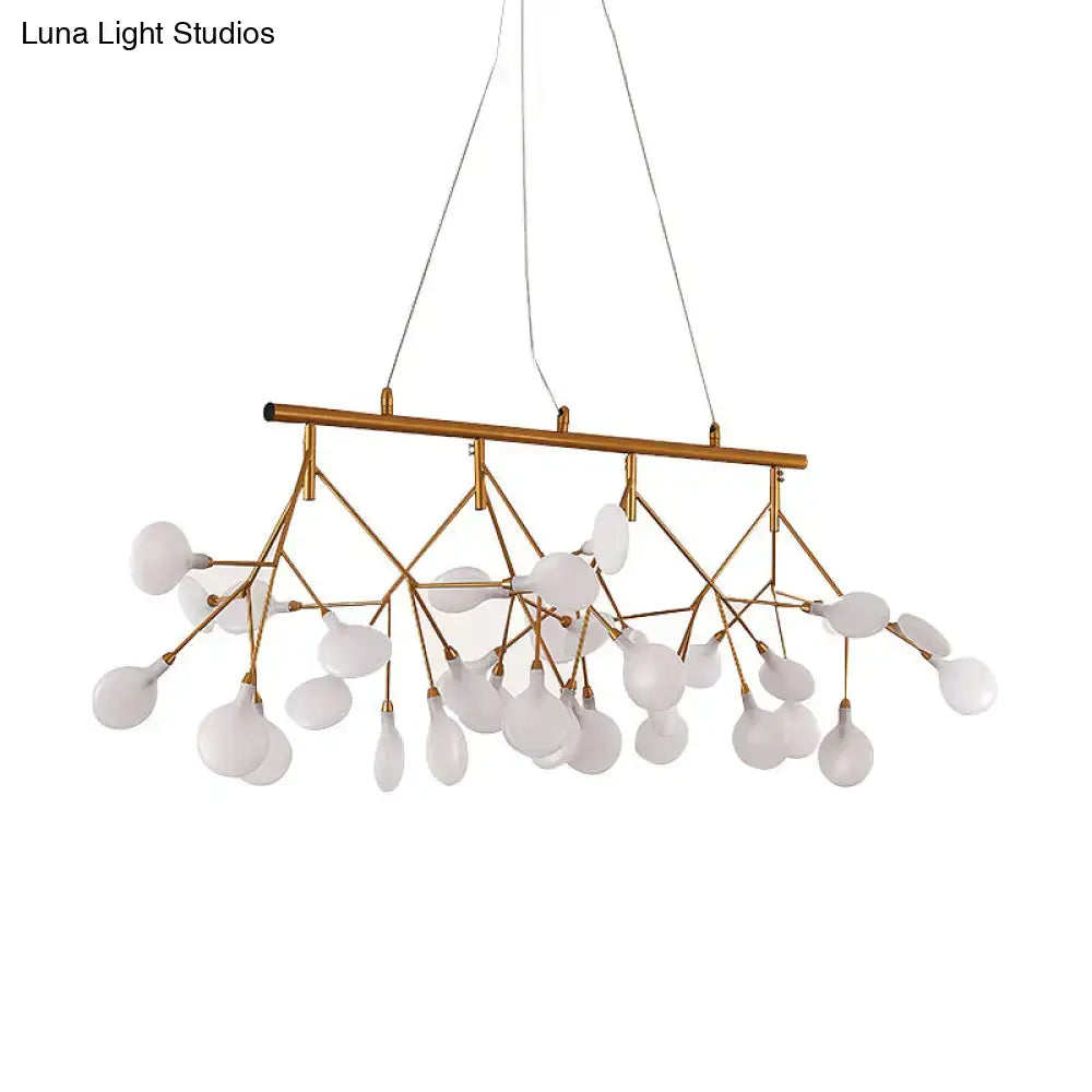 Gold-toned metal ceiling light with frosted glass globe shades in a tree branch design for minimalist dining room