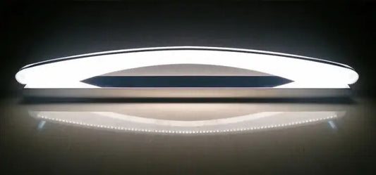 Modern white DecorBites LED mirror light fixture with sleek curved design and central dark accent strip for makeup bathrooms