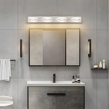 Modern white DecorBites led mirror light with four circular LED bulbs mounted above a mirrored medicine cabinet