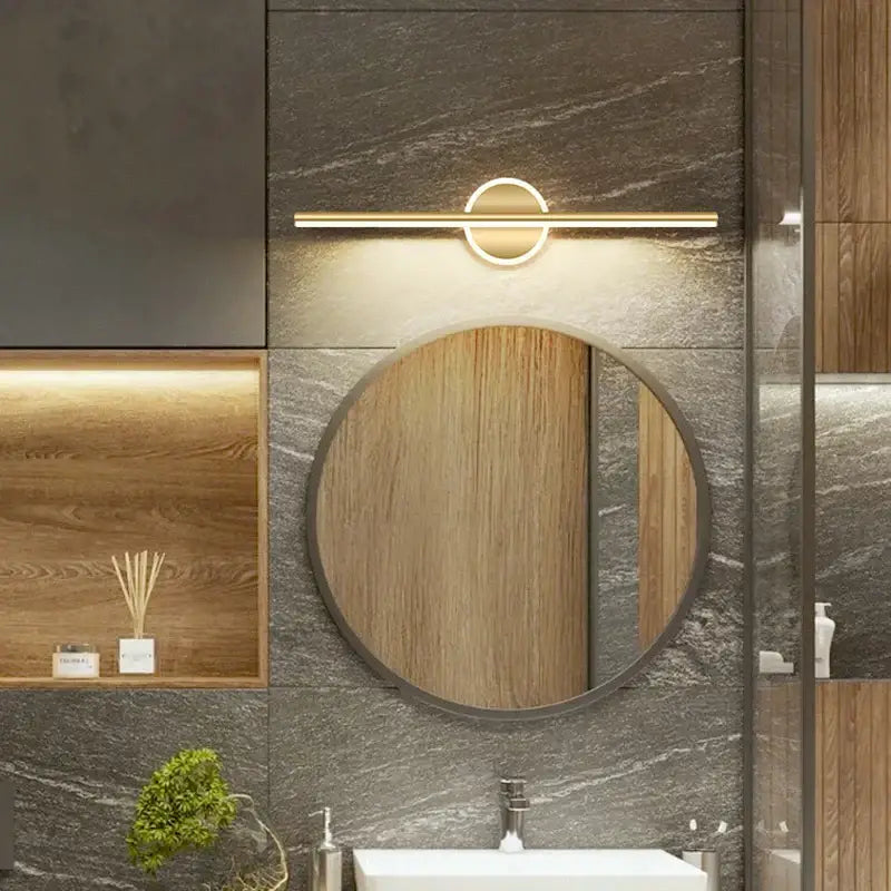Modern gold-toned DecorBites LED mirror light wall lamp with sleek bar and circular accent above wooden bathroom mirror