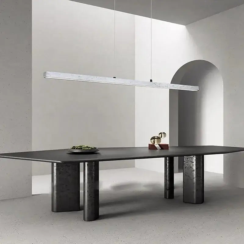 Modern black matte dining table with cylindrical concrete legs paired with decorbites led natural marble hanging chandelier