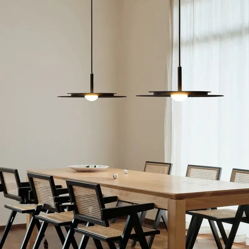 Modern black decorbites™ led nordic flying saucer chandelier with disc-shaped lights and warm bulbs above dining table