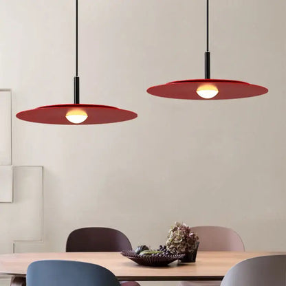Two modern red led flying saucer chandelier pendant lights with sleek black cords and disc-shaped shades by decorbites