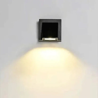 Black square DecorBites LED outdoor wall light with sleek modern design and warm yellow illumination for porch use
