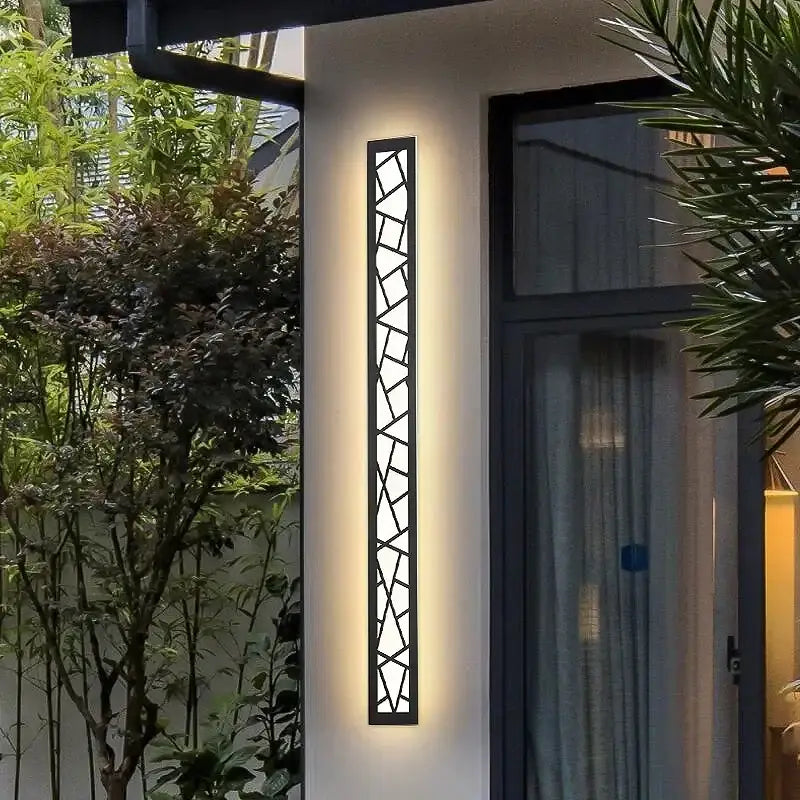 Modern black-framed DecorBites™ outdoor wall lamp with geometric glass panels and warm LED light for villa porch use